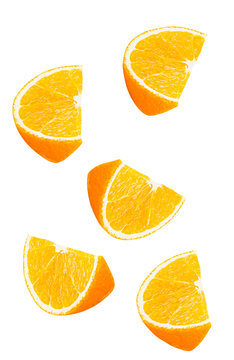 Isolated falling orange fruits pieces. Slices of orange in the air isolated on white background with clipping path
