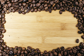 Brown coffee beans frame on a wooden board background