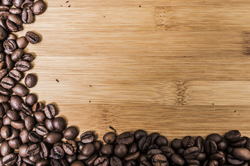 Dark brown texture coffee grains edge frame on a wooden surface