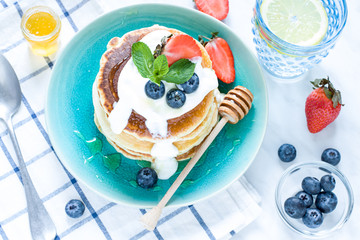 Stack of pancakes on the plate. Morning breakfast with berries on the table. Close up