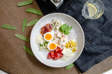 Top View Healthy Hearty Cobb Salad with Chicken, Bacon, Tomato, Onions, Eggs, green beans. American food. Close up, home made