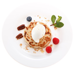 Serving pancakes with ice cream and fresh berries on the plate. Isolated on white background.