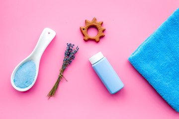 Skin care products for kids with lavender. Bottle, spa salt, towel and toy on pink background top view copy space