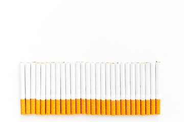 Tobacco. Row of cigarettes on white background top view copy space