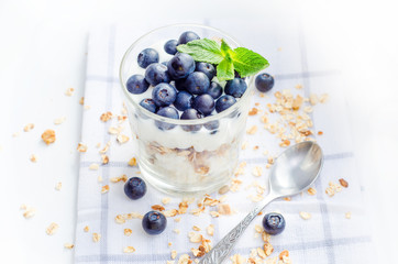 Top view healthy breakfast of homemade granola cereal with blueberries, nuts and fruit, honey with drizzlier background. Morning food, Diet, Detox, Vegetarian concept.