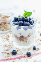 Top view healthy breakfast of homemade granola cereal with blueberries, nuts and fruit, honey with drizzlier background. Morning food, Diet, Detox, Vegetarian concept.