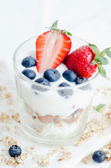 Top view Healthy breakfast of homemade granola cereal with strawberry, nuts and fruit, honey with drizzlier background. Morning food, Diet, Detox, Clean Eating, Vegetarian concept.