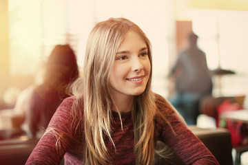 Portrait of beautiful smiling young woman in cafe