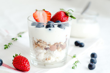 Healthy breakfast of homemade granola cereal with strawberry, nuts and fruit, honey with drizzlier background. Morning food, Diet, Detox, Clean Eating, Vegetarian concept.