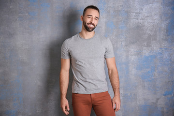 Portrait of handsome smiling young man near color wall