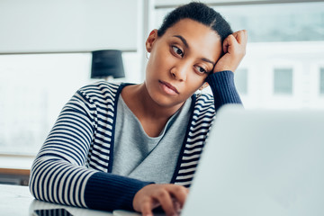 Tired businesswoman working on laptop