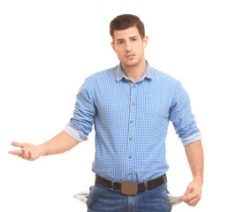 Handsome young man showing empty pockets on white background