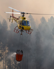 Firefighter Helicopter Dropping Water on a Fire. © bruno ismael alves