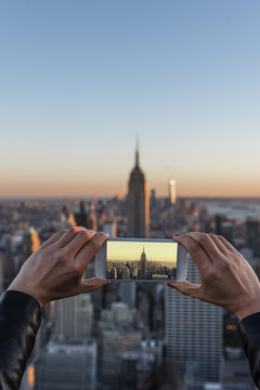 Woman taking a picture of New York skyline.