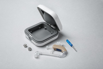 Hearing aid with accessories on light background