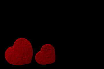 Red felt hearts isolated on a black background - valentines, love