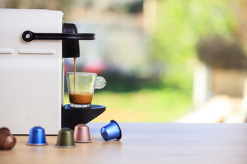 Espresso coffee machine on a wooden table, blur background, space for text