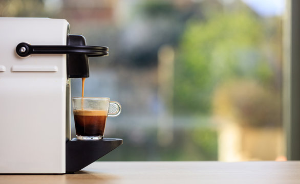 Espresso coffee machine on a wooden table, blur background, space for text