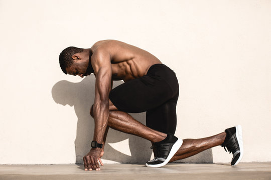Black athlete sprinting on the street.