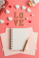 Flat view of blank notepads with valentines hearts and decoration on pink background with copy space. Symbol of love. Happy Valentines Day background.Saint Valentine's Day concept.