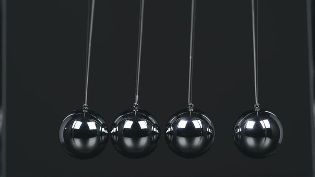 Slow motion shot of a Newton's Cradle.