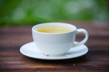 porcelainl cup with green tea on table