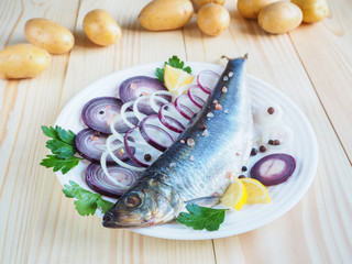 A delicious salted fish herring on the plate. Russian  cuisine.
