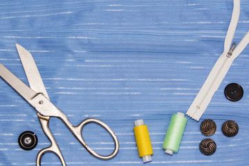 Background of sewing: scissors, thread, needles, measuring tape close up top view.