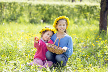 smiling children outdoors collect Easter eggs in basket