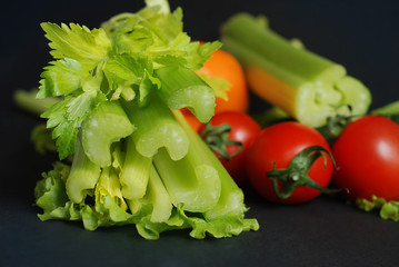 Celery Closeup over Black background. Leaves and Stem of Fresh Organic Green Celery. Healthy Eating, Vegetarian Food, Diet, Dieting Concept.