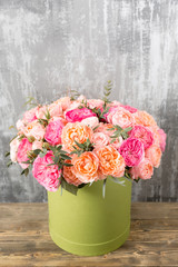 beautiful bouquet of mixed flowers in a box on wooden table. the work of the florist at a flower shop