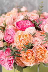beautiful bouquet of mixed flowers in a box on wooden table. the work of the florist at a flower shop