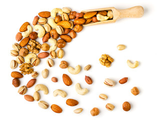 Nuts spill from a wooden scoop, top view.