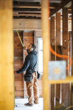 Carpenter man working on jobsite measuring