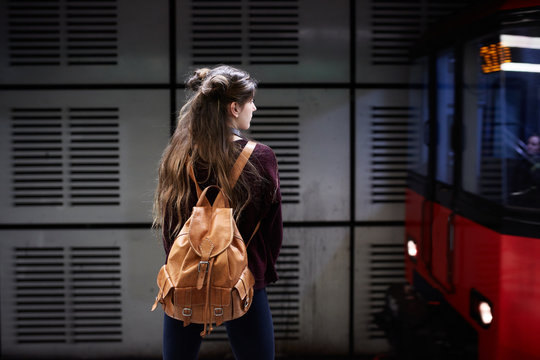 Young woman with bagpack waiting for the subway