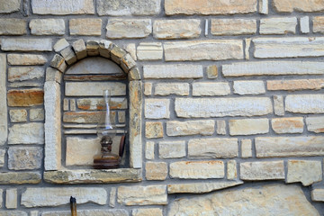 A decorative gas lamb on a stone wall