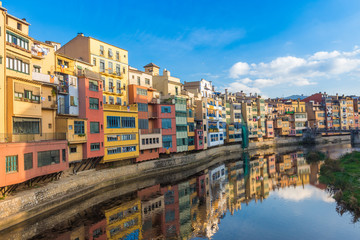 Fototapeta na wymiar Colorful river-front houses lining the Onyar river, mostly built on top of old medieval defense walls, Girona, Catalonia, Spain