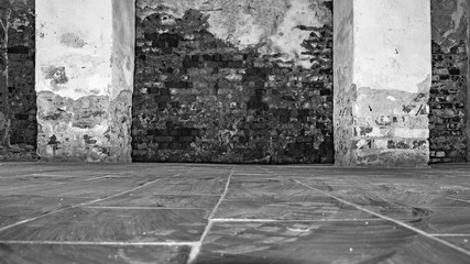 part of the room with destroyed brick walls, rectangular two columns with crumbling plaster at the base