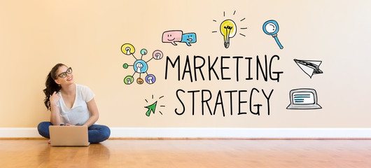 Marketing Strategy text with young woman using a laptop computer on floor