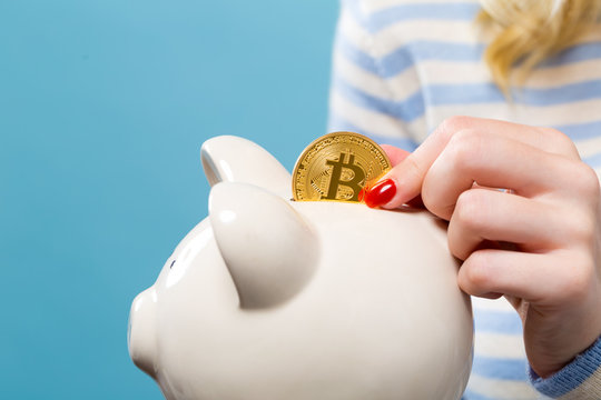 Woman with bitcoin and a piggy bank on ablue background