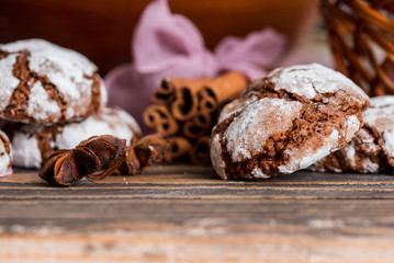 biscuits with chocolate cracks. Morning breakfast. On a wooden plate on a dark textured wooden background. Lavender and cardamom, cinnamon sticks on a purple napkin with ribbon. Place for inscription
