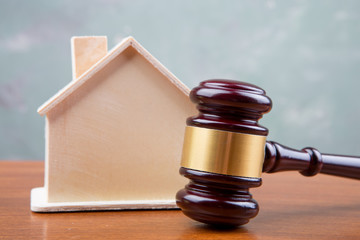 Real estate sale auction concept - gavel and house model on the wooden table