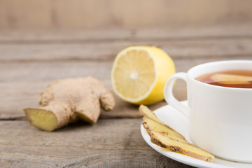 Ginger tea in a cup on wooden background