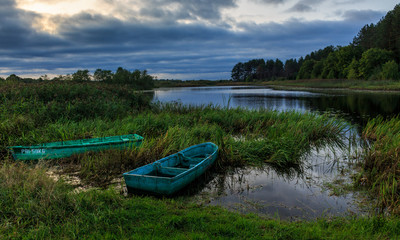 Obraz premium Decline against the background of boats and the forest lake
