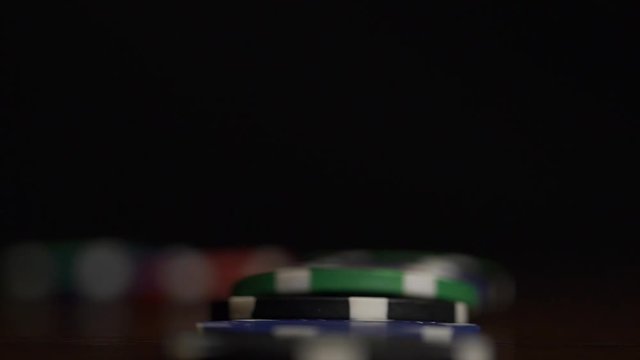 Poker Chips Falling. Poker chips stand in a row on a black background, a Domino effect