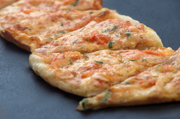 slices of delicious pizza with cheese and ham and tomatoes closeup
