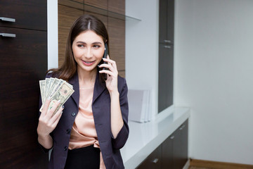 Businesswoman prompt pay money and talking about shares by mobile phone