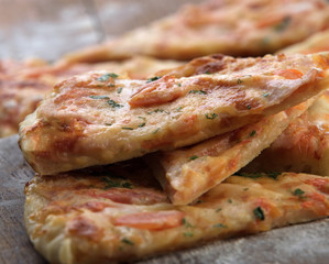 slices of delicious pizza with cheese and ham and tomatoes closeup shallow depth of field
