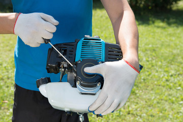 The man cutting a grass with the lawn mower. Closeup.