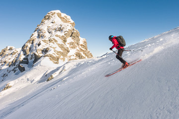 Side view of man skiing downhill steep slope